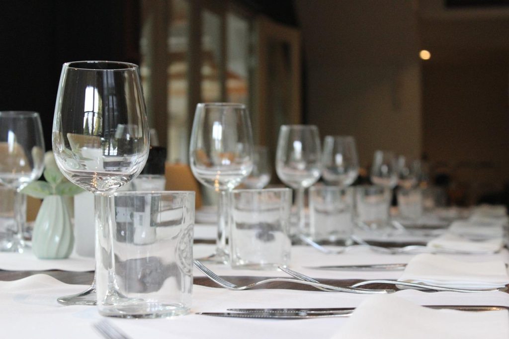 Elegante tafeldecoratie met gegraveerde glazen en bloemen voor het organiseren van een zakelijke diner